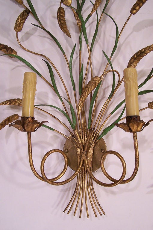 Two-arm carved wood and painted metal sconces with a wheat motif. 
Gilt and Parcel Painted sconces sockets are candleabra bases able to hold up to 60 watts each socket.  Recently Rewired.
There is a second pair available, please inquire.
