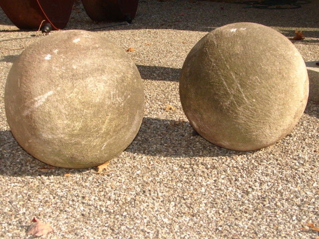 Impressive pair of carved stone ball finials, metal posts still intact.