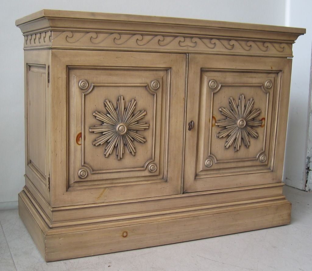 Very early Dunbar Furniture pine 2 door cabinet with carved starburst door fronts and wave trim.