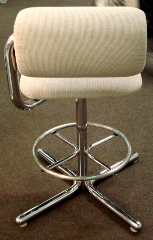 Set of four stools upholstered in thick sand cotton fabric. The sit swivels on the chromed base.  The back rest can be adjusted.<br />
Aluminum Footrests. Designed by Ray Wilkes