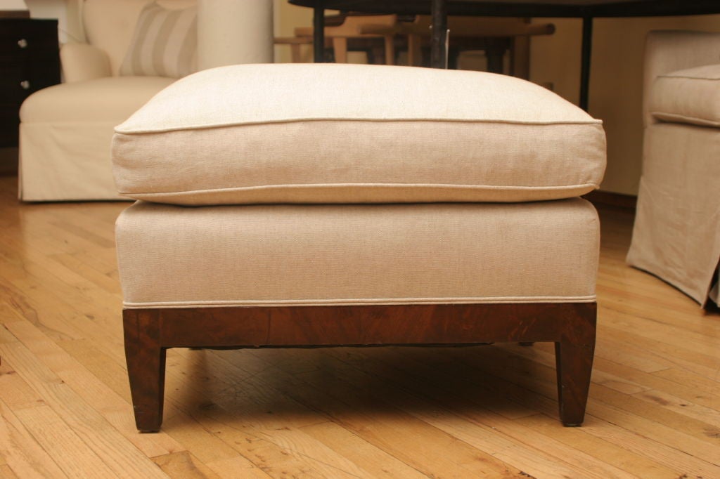 Upholstered in beige and white linen fabric with attached cushion. Mahogany wood frame with tapered legs.