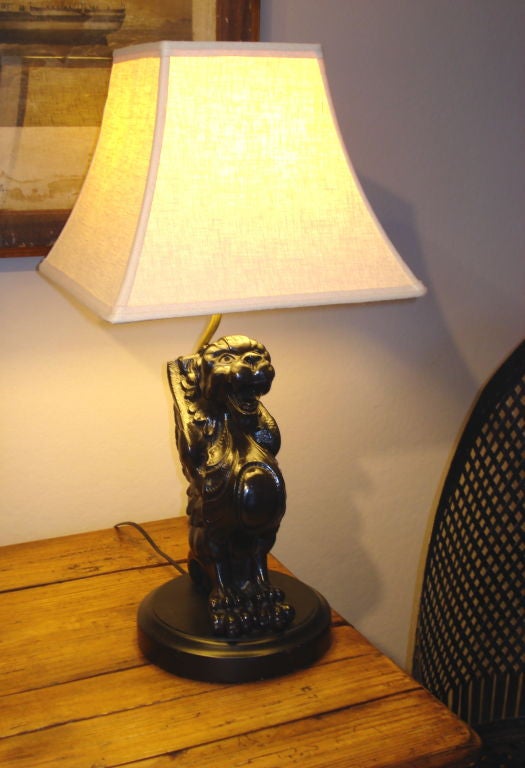 A pair of carved and ebonized griffins fabricated into lamps.