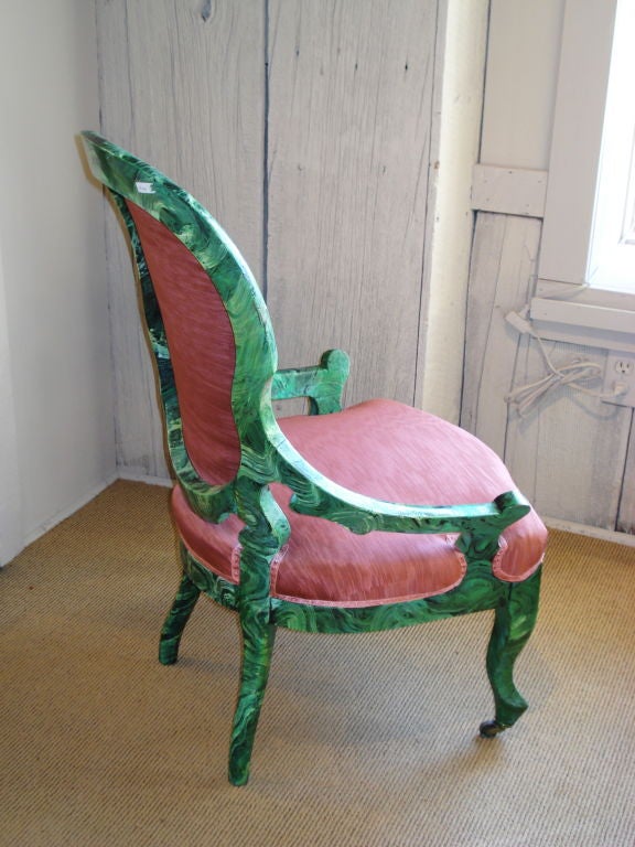 A pair of unusual and stylized, hand-carved and faux painted malachite chairs on casters.