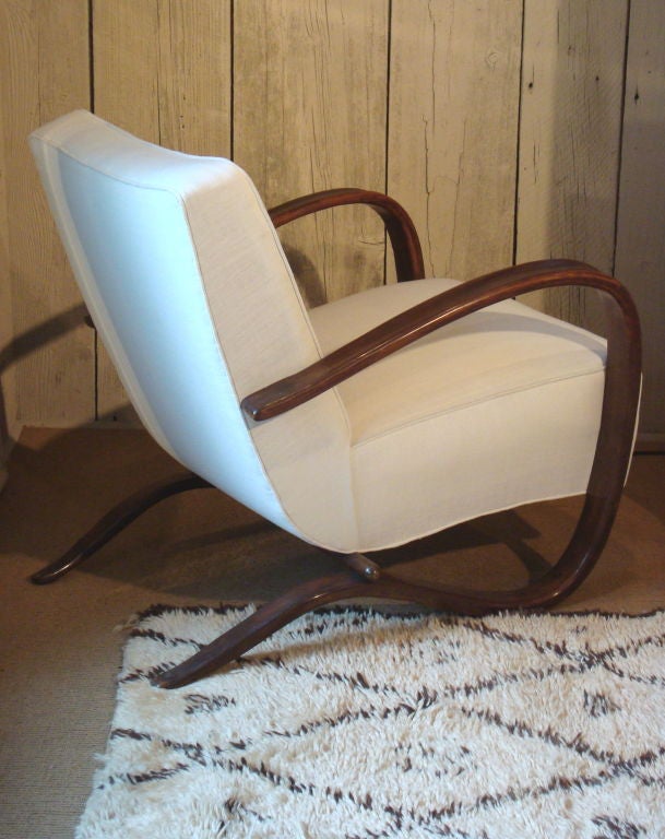 A classic pair of modernist club chairs with bent mahogany frames that serve as armrests and chair suports.  These chairs were recently rebuilt and reupholstered in a heavyweight Belgian linen.