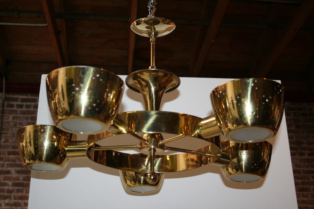 60's brass wagon wheel shaped chandelier with five perforated cups giving off beautiful lighting.