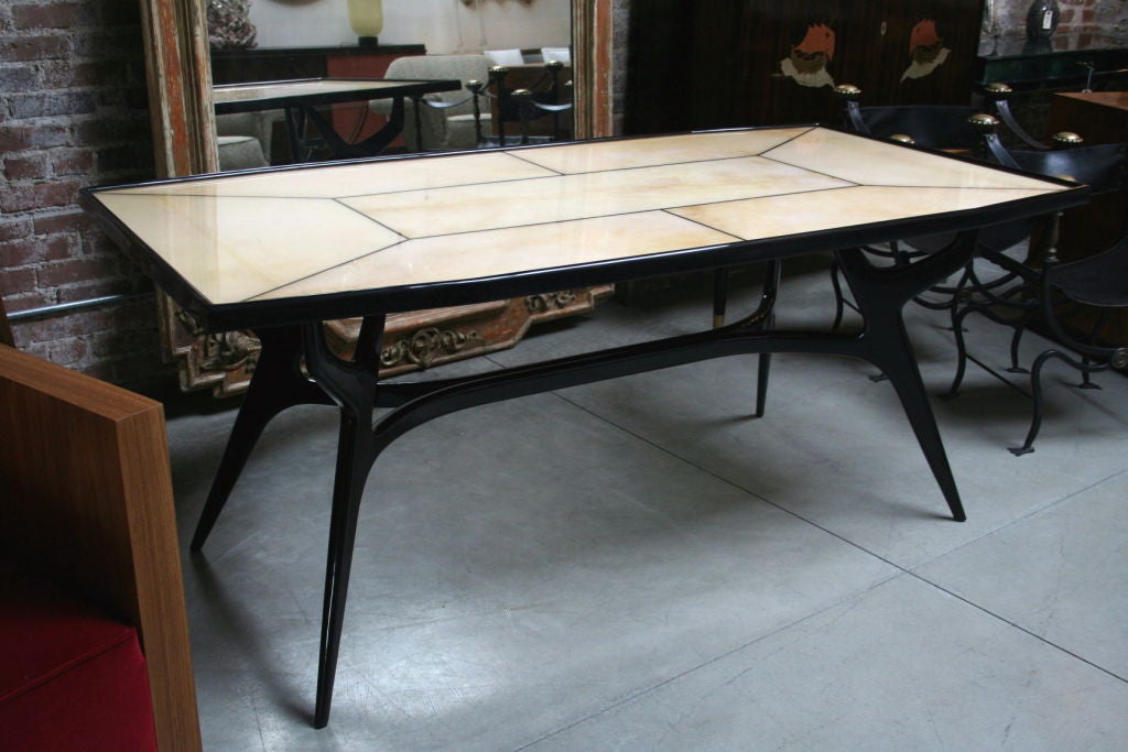 Black lacquer dining table with a parchment top protected with a layer of resin.