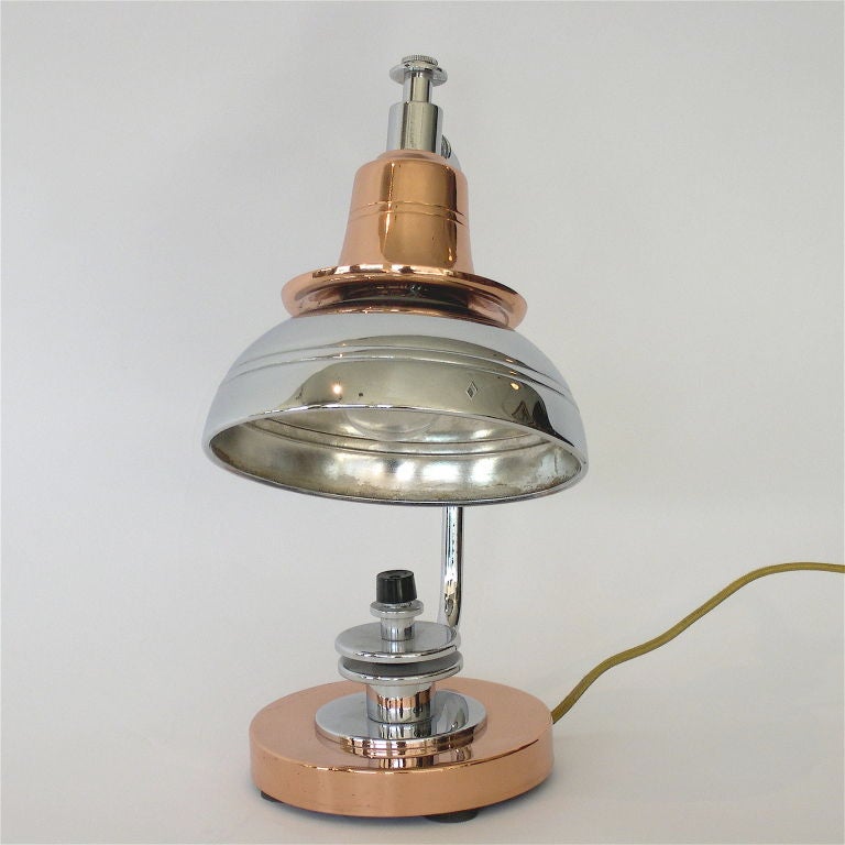 This great lamp was manufactured by the New York lamp company, Markel in the 1930's. It is finished in chrome with copper accents. The design of the shade lets the light from the copper tier shine on to the chrome part of the shade as well as out