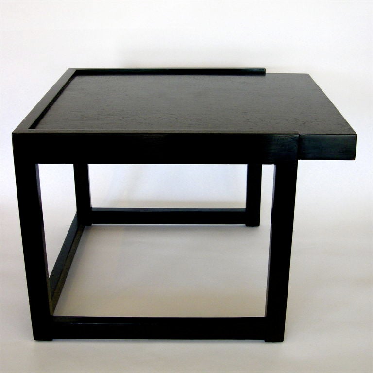 This highly stylized pair of end tables was designed by Paul Laszlo and manufactured by Brown and Saltman. The cantilevered tops oppose each other and a great asymmetry to the design. The oak veneer has an black-brown ebonized finish.