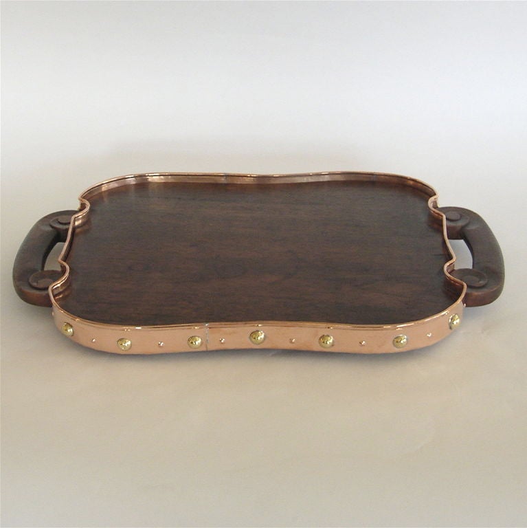 This beautiful tray was created by Hector Aguilar in the late 1930's. The design is a perfect blend of early Modern and Ranchero design. This tray is hand made of wood with copper and brass trim. The handles are carved. The copper banding is trimmed