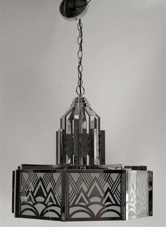 This Art Deco revival chandelier was designed and produced by Frederick Raymond in the early 1970's. It is mirrored and frosted glass inserted into a chrome frame with a frosted glass bottom insert. The chandelier holds three bulbs. The final height