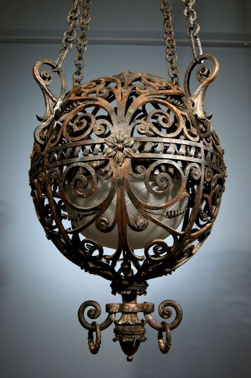 A Large Wrought Iron Spherical Lantern, Suspended by Four Handsome Chains and Decorated with Ribbon and Rinceaux Motifs.  Probably Venetian,  Circa 1920's - 30's. In the manner of Carlo Rizzarde.
