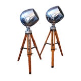 Pair of polished aluminum industrial spotlights on tripods
