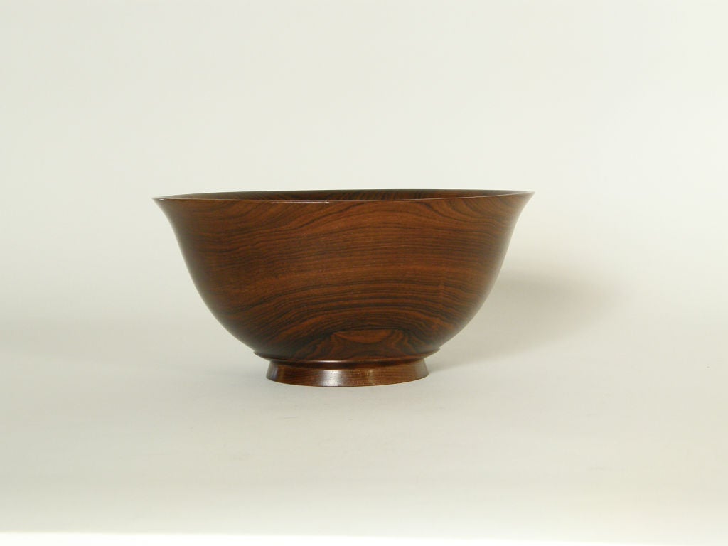 Beautifully turned rosewood bowl by Salisbury Artisans of Salisbury, CT, circa 1950s. This is a nice example of a modern take on a traditional turned wood bowl with a simplified classic silhouette that highlights the dramatic grain of the rosewood. 