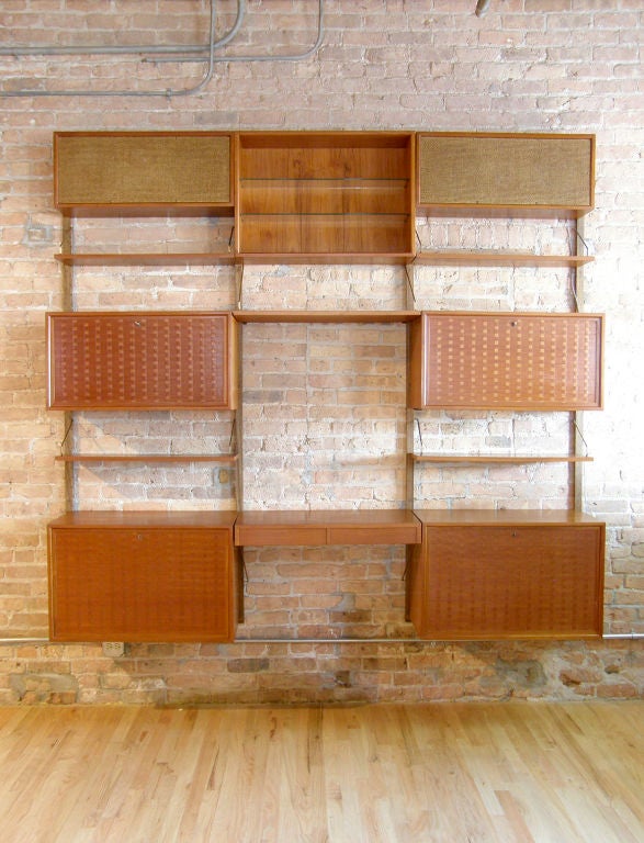 Cado wall system by Poul Cadovius. <br />
<br />
4 storage cabinets with woven veneer fronts, desk surface, display box with glass shelves, 5 open shelves and nice quality vintage speakers that sound great.