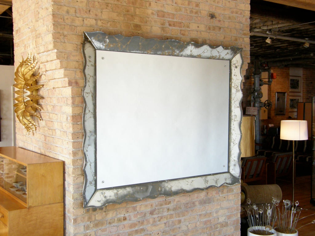 Monumental wall mirror with scalloped glass frame