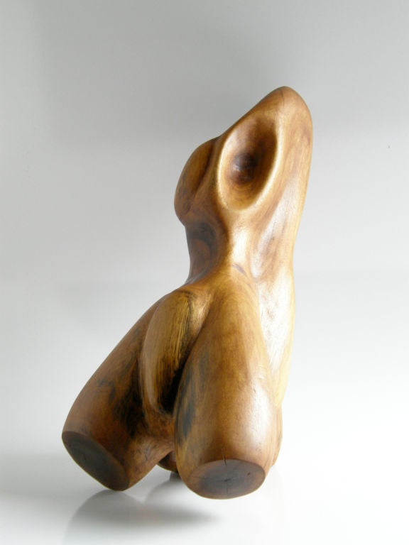 This hand carved walnut torso sculpture by Slim Schramm is an abstract reclining figure. Schramm's exploitation of the natural growth patterns and irregularities of the wood lend to the warm, organic quality of this piece. It came from the artist's