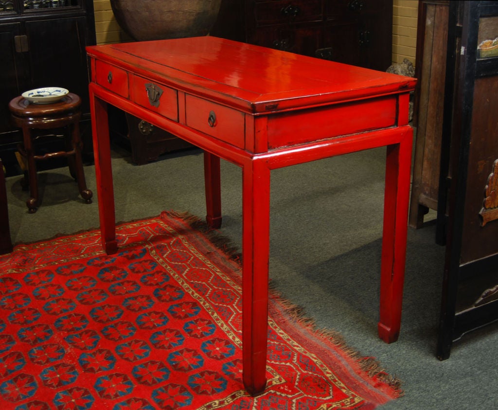 Provenant de la riche ville de Suzhou en Chine au 19e siècle:: ce bureau en bois d'orme du Sud laqué en rouge possède trois tiroirs:: une taille haute et des ferrures en laiton représentant un papillon.<br />
<br />
Collection Pagode Rouge # : 
