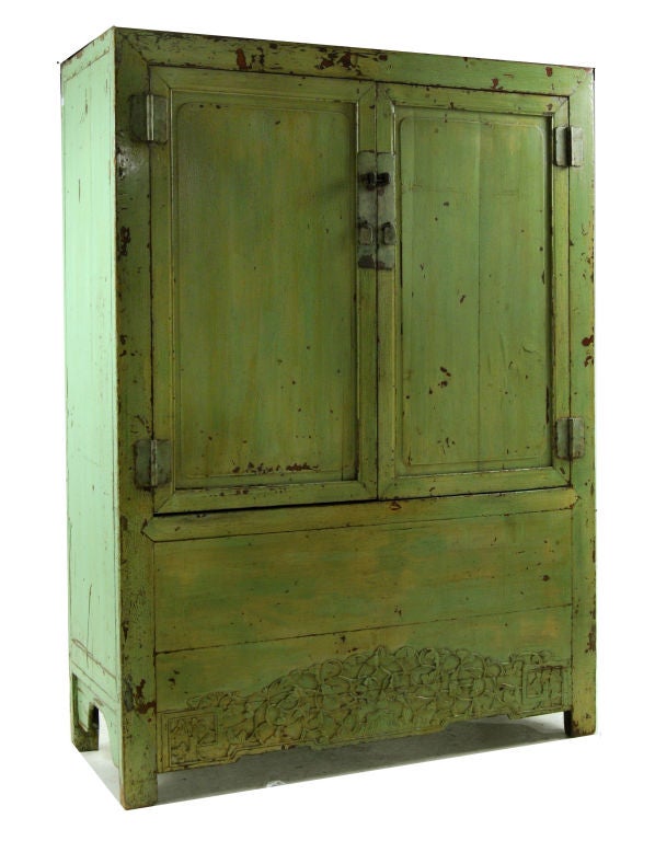 Chinese cabinet with unusual green lacquer with floral carved apron, and lacquered brass hardware.  Interior contains one shelf with three drawers, and a hidden compartment below.<br />
<br />
<br />
Keywords:  Cabinet, armoire, entertainment