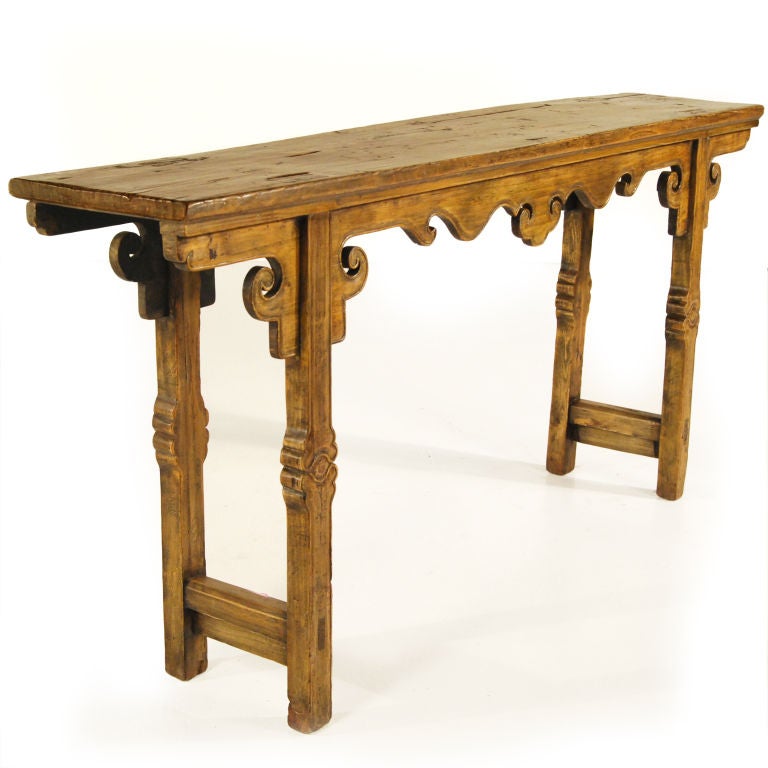 The artisan who carved this provincial table out of pine added personal touches: highly carved apron, legs, and spandrels in the form of lingzi (auspicious mushroom). It was made over 150 years ago in the Gansu region of China. Long, narrow tables,