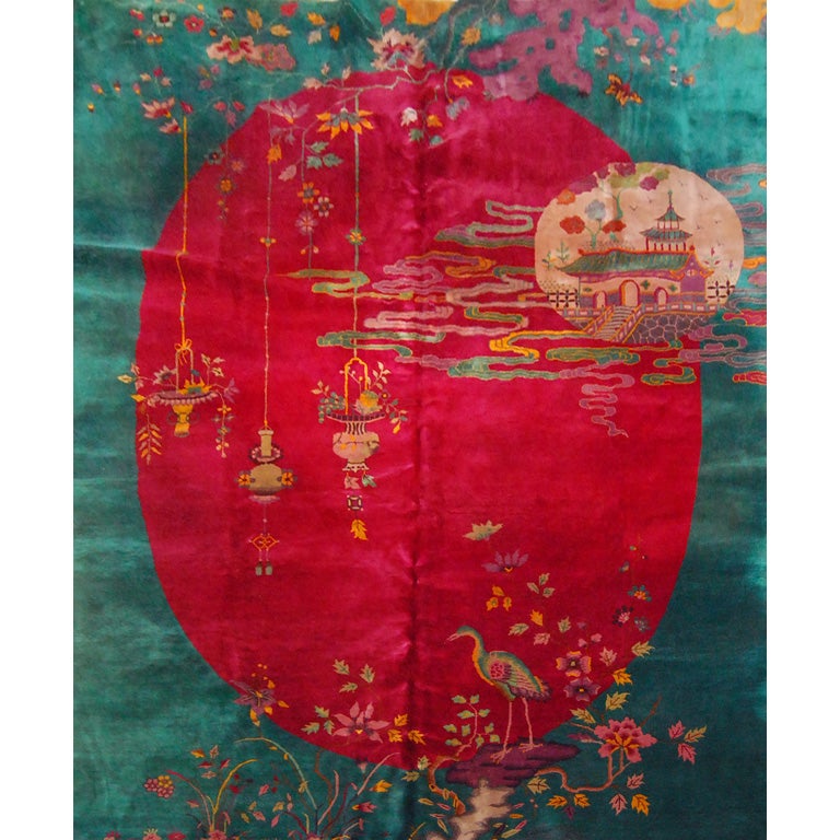Fantastic Chinese Deco carpet with turquoise field with a deep cranberry oval inset with hanging lanterns, a Chinese temple suspended on incense smoke and vines and flowers at each end, all in multicolored vegetable dyed wool; from 1930's