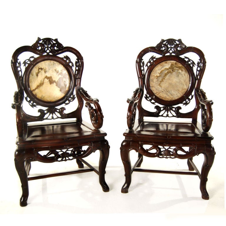 A pair of turn-of-the-century European influenced Chinese blackwood chairs carved to mimic bamboo shoots, with marble inset backs.<br />
<br />
Pagoda Red Collection #:  R044<br />
<br />
<br />
Keywords:  Chair, armchair, side, desk, dining