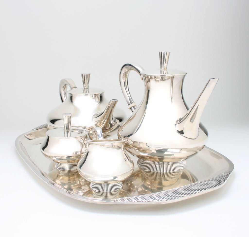 This is a great looking and substantial set.  It consists of a tray, creamer, covered sugar, coffee and tea pot.  The set is signed GK over a clover leaf in a shield. <br />
The complete set together measures 17.