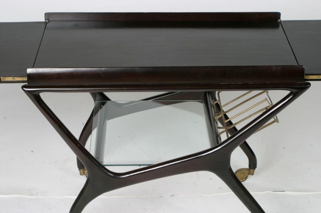Italian walnut bar cart by Cesare Lacca. Top slides out for extra serving space, glass shelf and brass bottle holders.