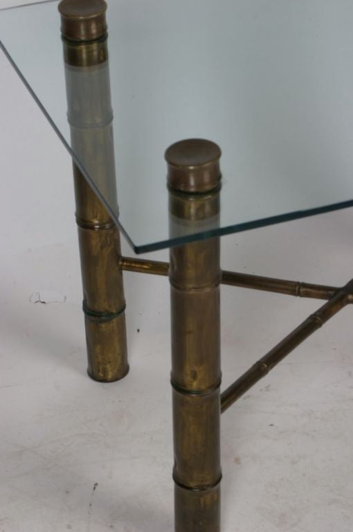 Table en faux bambou en laiton épais avec traverse en X et table d'appoint avec plateau en verre. Patine chaude sur le laiton. Légères rayures sur le verre. 