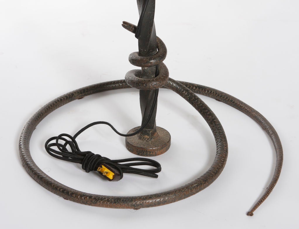 An early 20th century French Fer Forge wrought iron floor lamp with a coiled snake base. Wired for US with a custom painted shade.