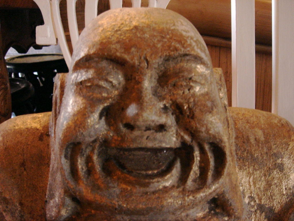 Heavy Stone Buddha, laughing with open mouth. Previously washed in gold colored paint, robe was blue and red.  Paint mostly worn off with age.