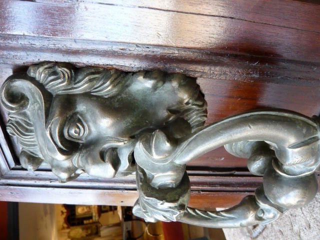 A handsome door knocker representing a SATYR wrapping its tongue over two DOLPHINS