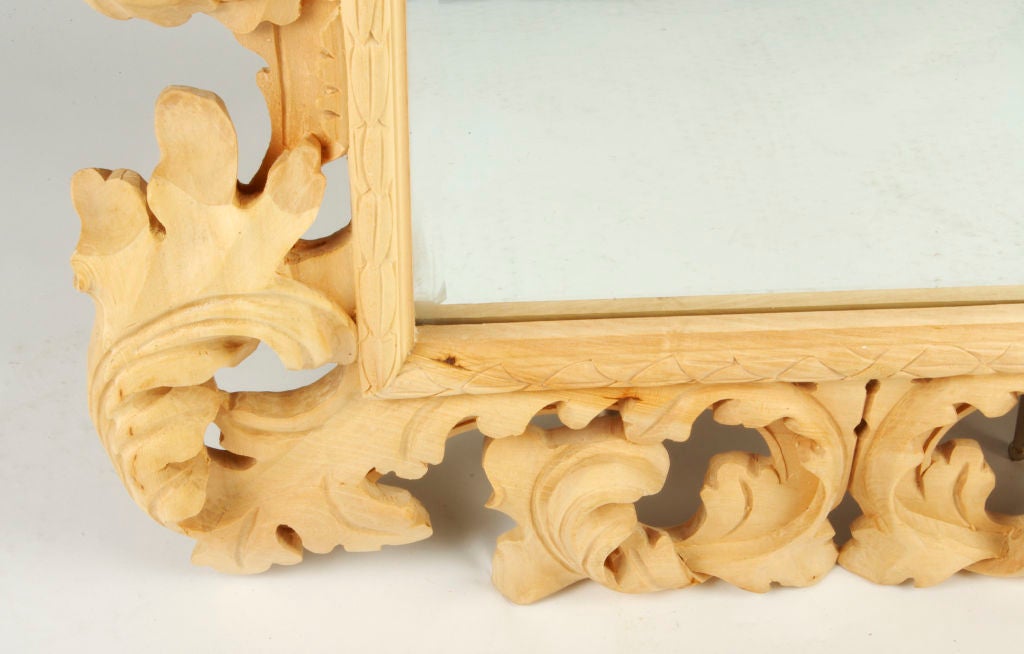 Beautiful mirror with an unfinished wood acanthus leaf frame.  The mirror has a beveled edge.