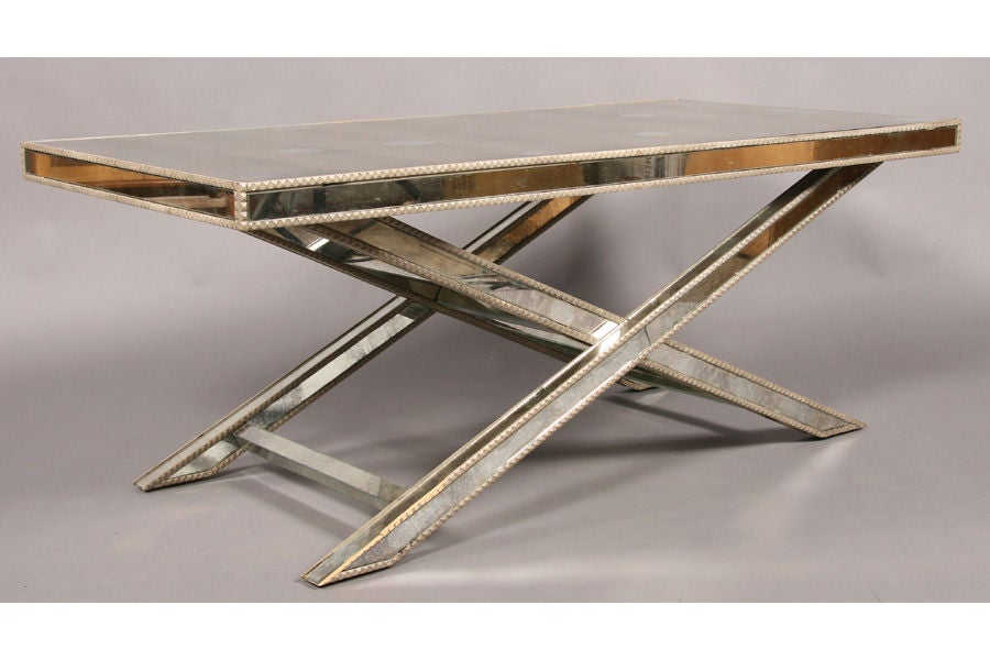 Amy Howard Regency style mirrored coffee table. <br />
Chipped carved edge with mirrored top and side panels over an x-form base.