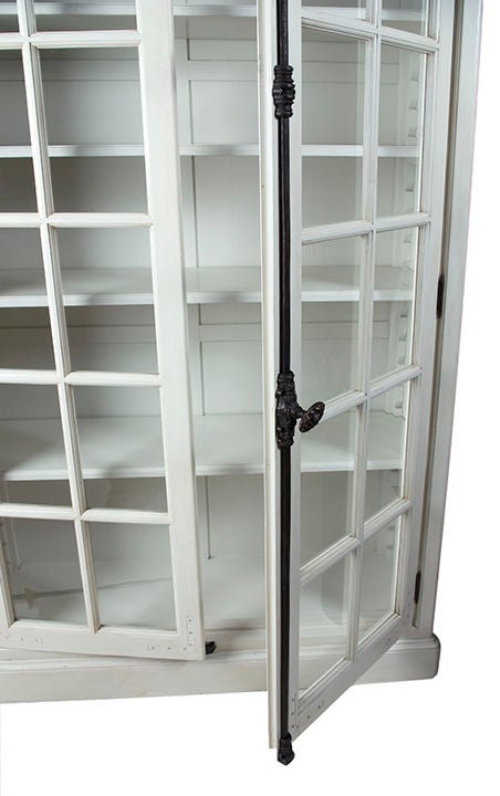 Antique white painted wooden bookcase with glass doors, french bronze hardware and several shelves.