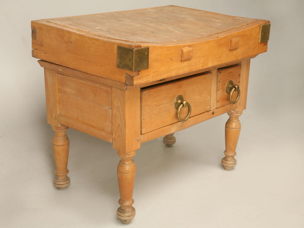 Vintage American butcher block made from maple with the original solid brass hardware, a dovetailed top and wooden-peg constructed legs. This piece has been in the owner's personal collection for 35 years. We weren't smart enough to ask where it