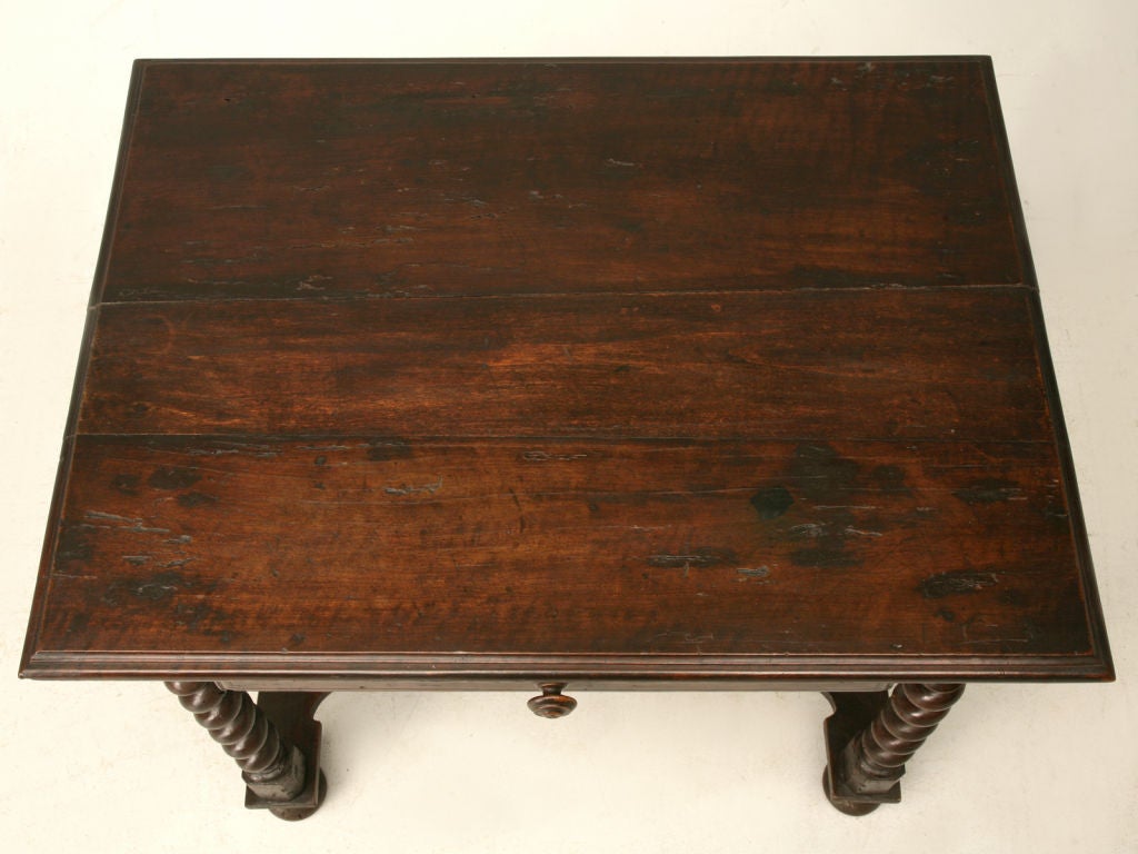 French Louis XIII walnut writing table with barley twist legs and a curved cross stretcher with a finial. Wooden-peg constructed.