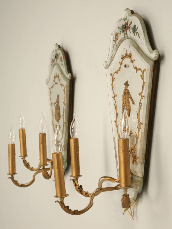 Pair of stunning Italian hand-painted eglomise 3 light wall sconces with silver leaf background and beveled glass. These jewel-like sconces are spectacular even though one is cracked. Perfect for any room of the home, these sconce are not only