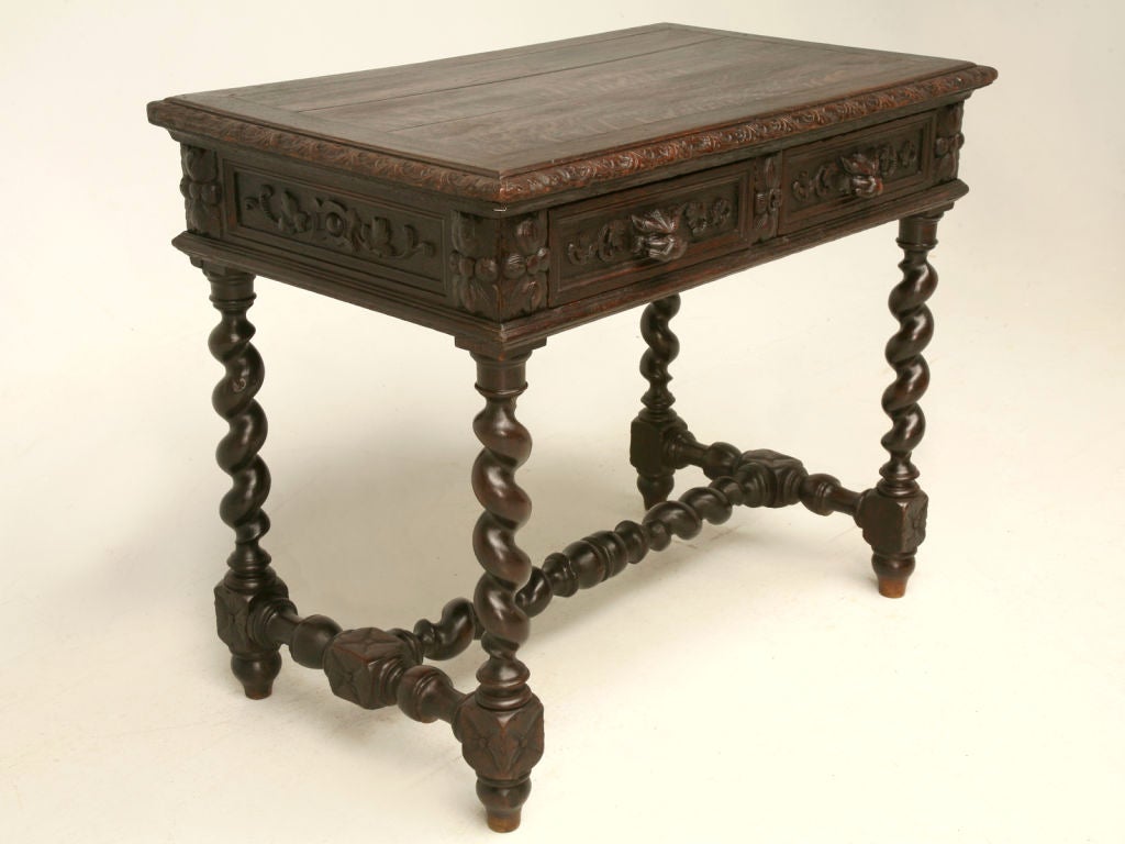 Outstanding hand-carved petite antique French oak writing table with barley twist legs and stretcher, center lock and two hand-dovetailed drawers (one has dividers) with animal pulls. Loads of carving on this great petite library table, just the