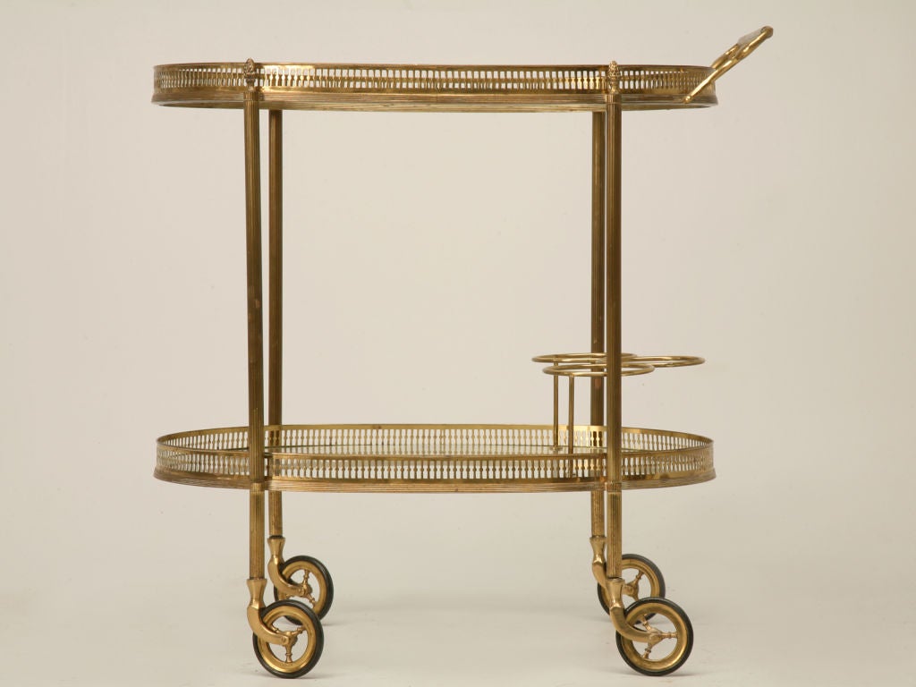 Beautiful vintage French solid brass and glass bar cart with three bottle holders and an elegant trim.
