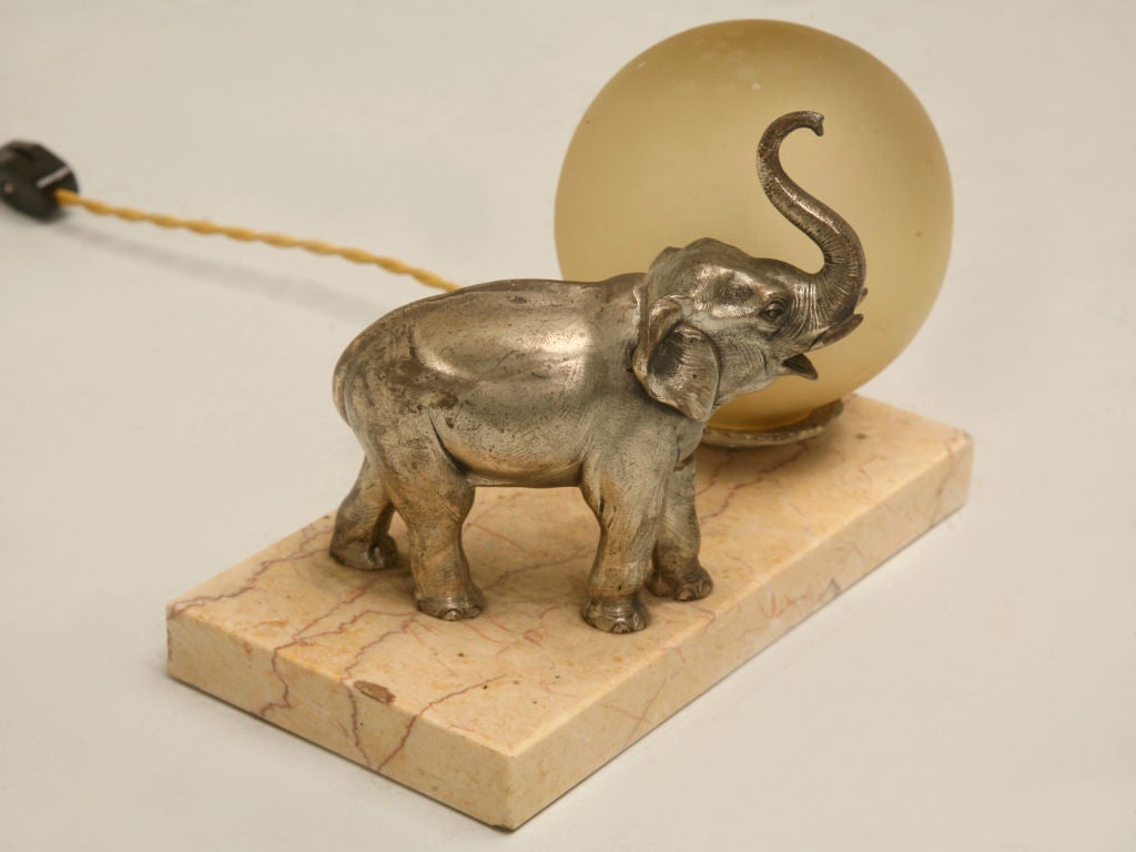 Vintage French Art Deco elephant lamp cast from spelter with a marble base and glass globe. Has been completely rewired by our in-house electrician.