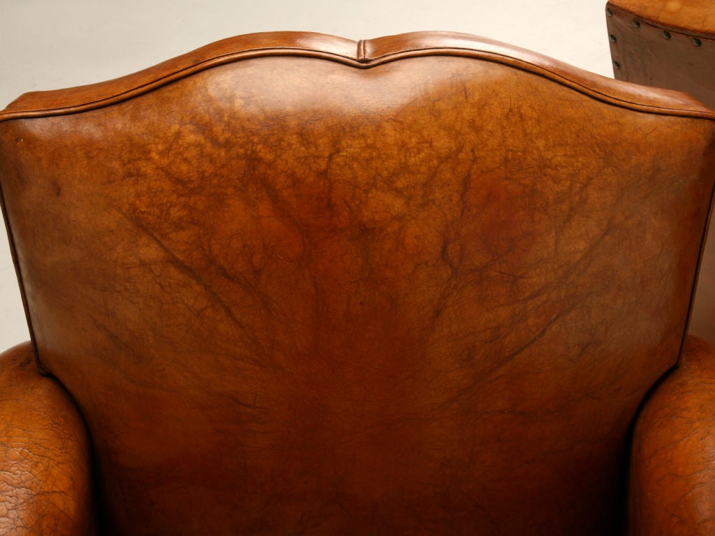 Fabulous pair of French 40's club chairs with the original supple leather and highly stylized moustache backs. These chairs are the epitome of French Art Deco club chairs. While they used to be very easy for us to get they have become quite the