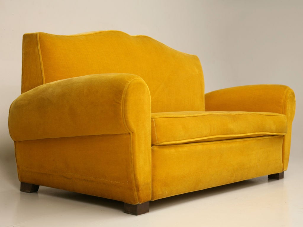 Intriquing Vintage French Art Deco moustache back settee with it's original mustard colored mohair upholstery. Settee's such as this are very well known to Americans as Club Furniture, as they were popular throughout Europe in nightclubs and