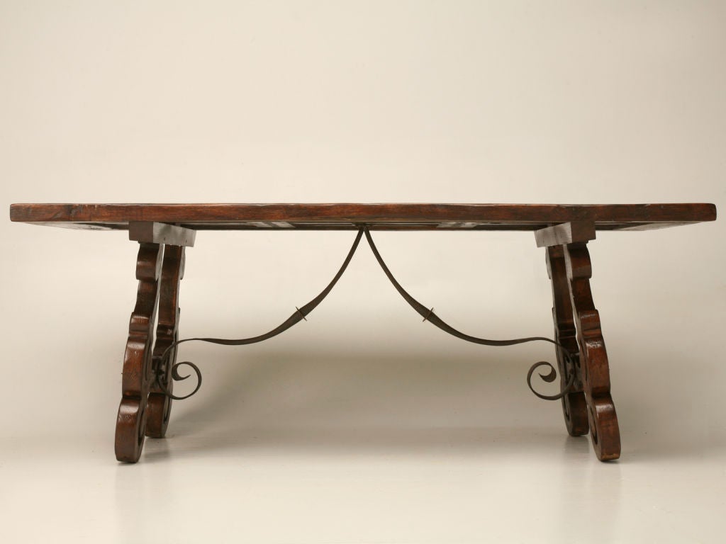 Breathtaking unusually wide, hand-carved Spanish oak dining table featuring ornate lyre form legs, curling hand-wrought iron stretcher and a spectacular rustic solid oak inset board top. An amazing table! Truly gorgeous!