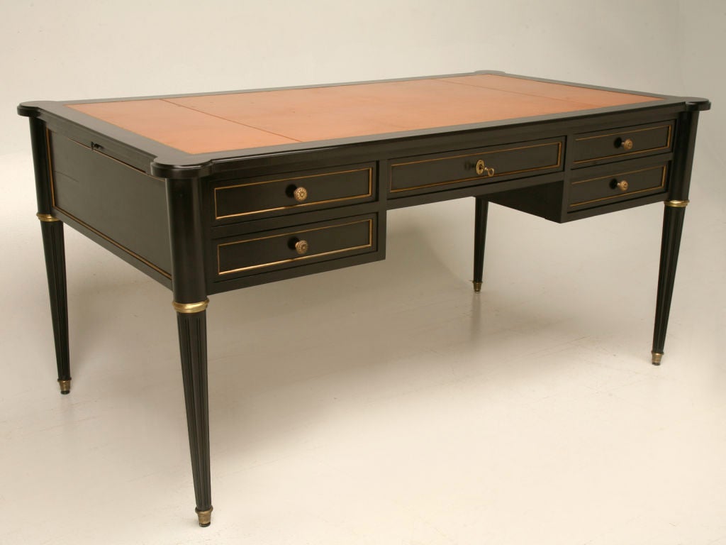 Spectacular vintage French Louis XVI style ebonized desk with the original leather top, 5 beautifully hand-dovetailed drawers and its original brass trim. This desk is breathtaking, the (Hermes signature color) leather top takes this fine desk up