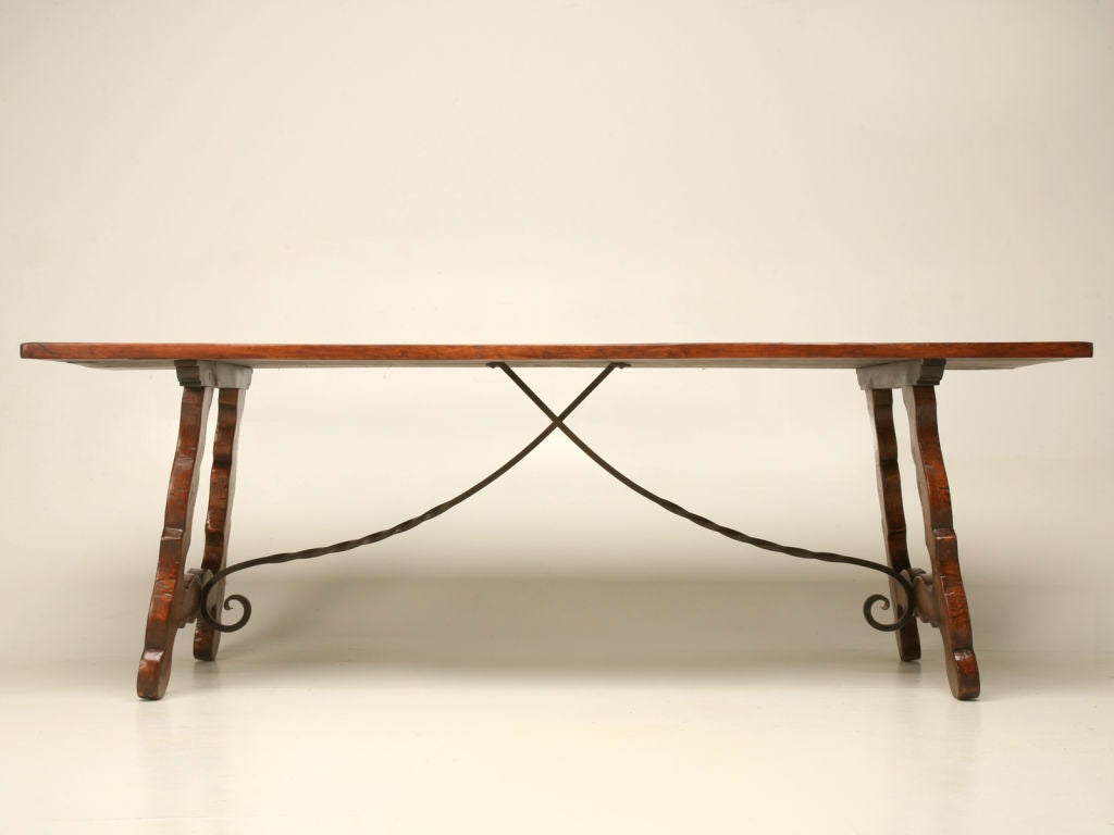 c1800's antique Spanish solid cherry dining, or console table, featuring ornate lyre-shaped legs and a curling wrought iron stretcher. This is the only 