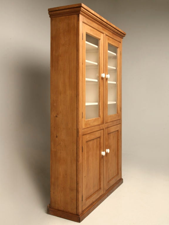 Stunning antique English pine glazed 2 over 2 china cabinet. Perfect in a casual setting-- Awesome utilized in a lake home or country retreat, this nice piece could display collections as well.