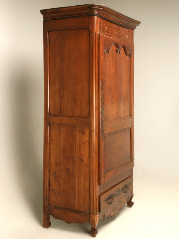 Beautiful Louis XV bonnetiere from Brittany made from solid cherry with all it's original hardware, including it's full hinged door, drawer pulls, and large highly decorative escutcheon plate. The real showstopper on this particular piece is the