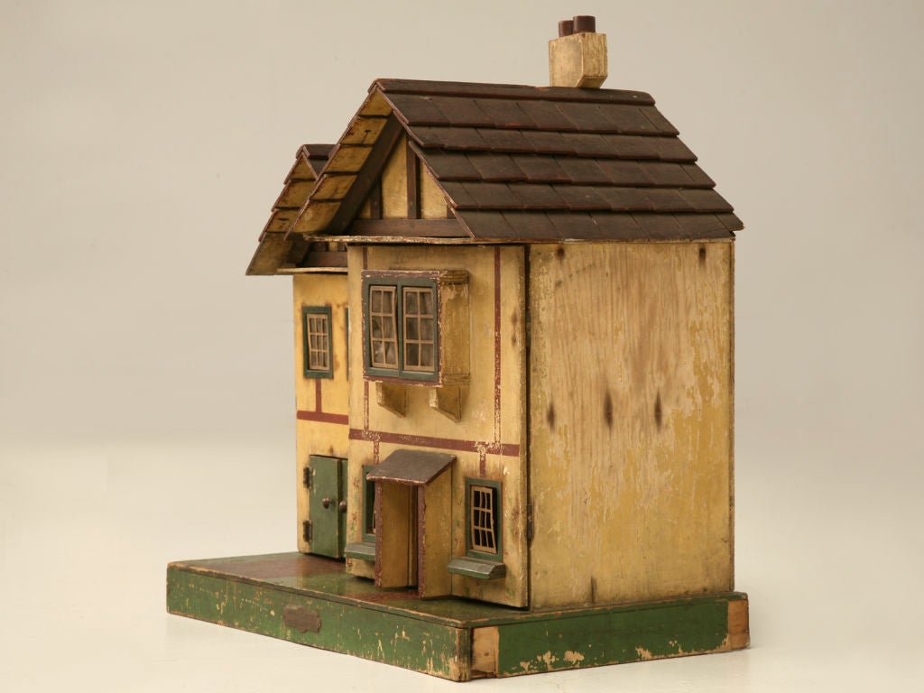 Quaint vintage English Tudor child's toy dollhouse, with all the charm and personality of yesteryear. Retaining its original paint,windows, wall papers, and deco fireplace lets us know right off the bat that some youngster took pride in ownership of