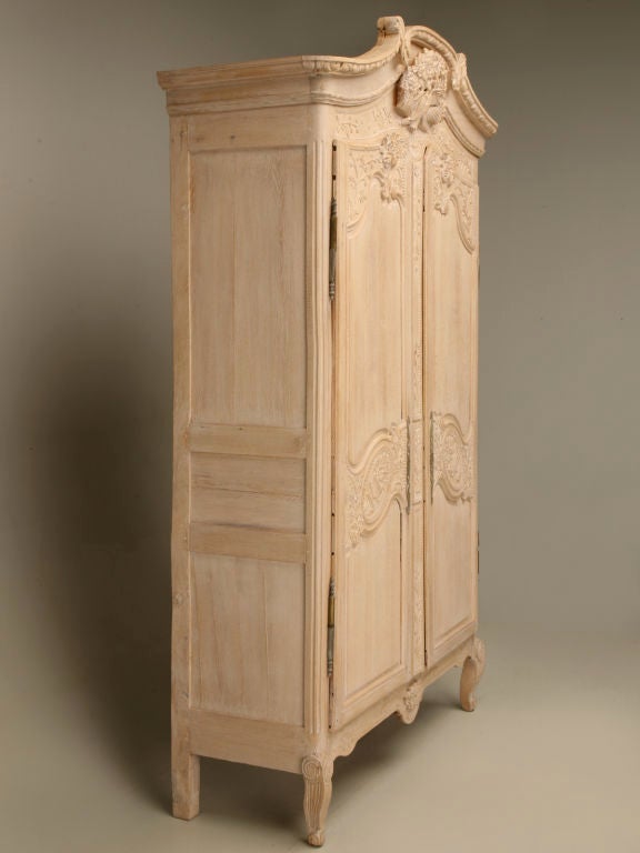 Breathtaking antique French limed oak wedding armoire from Normandy which we had shipped to England where they submerged it in a caustic tank, that began the 6 month liming process. Upon its arrival in the U.S. it began to shrink for the next 6