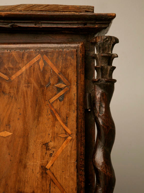 Handmade primitive Spanish desk with extensive inlay. We were told by a European antique expert that this piece is from the 1500's. It has beautiful hand-cut, crude barly twist columns and 7 hidden drawers inside. The top exterior drawer is faux.